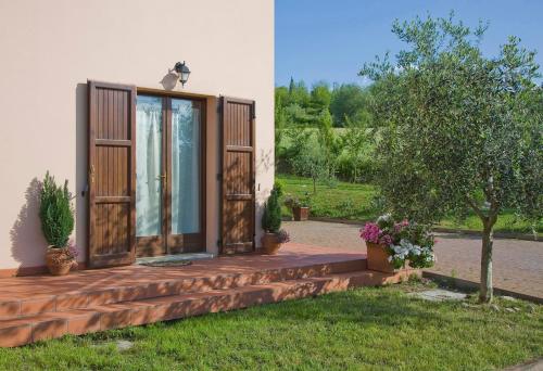 una casa con portico in legno e albero di B&B Rosaverde a Mulazzano