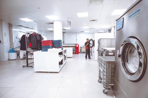 a person standing in a store with a washing machine at Titanic Hotel & SPA in As Sulaymānīyah