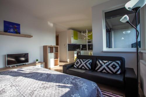 a bedroom with a bed and a couch at Air-Conditioned City View Apartment 24h check-in in Bratislava