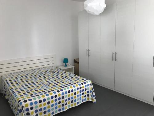 um quarto com uma cama com um cobertor de bolinhas em Riviera lanterna em Scoglitti