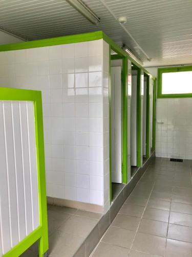 a hallway of an empty building with green accents at Camping Du Paquier Fané in Chagny