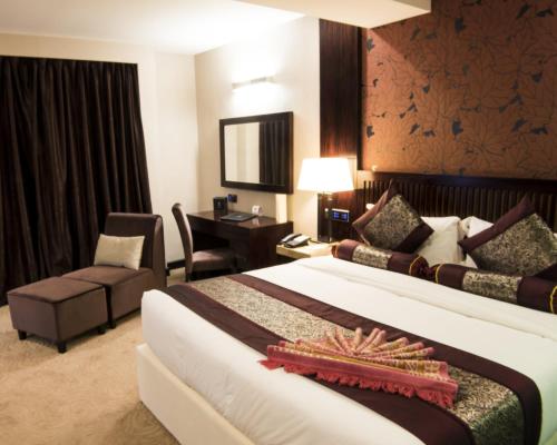 a hotel room with a large bed and a desk at Royale Signature Hotel in Alor Setar