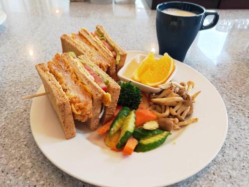 a plate of food with a sandwich and vegetables and a cup of coffee at My Chateau in Checheng