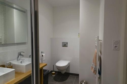 une salle de bain blanche avec des toilettes et un lavabo dans l'établissement La Lanterne, à La Baule