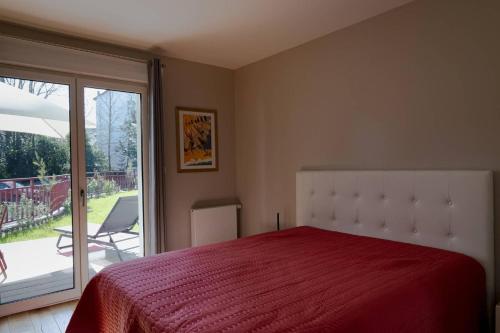 une chambre avec un lit et une porte coulissante en verre dans l'établissement La Lanterne, à La Baule