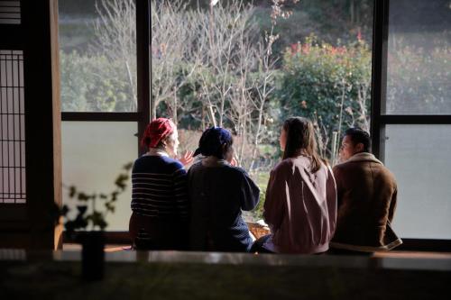 a group of people sitting in a room looking out a window at Tubakiann in Kikuchi