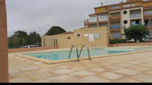 une piscine devant un immeuble dans l'établissement Vias Plage : résidence sécurisée bord de mer, à Vias