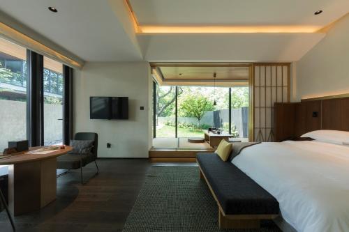 Un dormitorio con una cama grande y una ventana grande. en MUH SHOOU XIXI HOTEL HANGZHOU, en Yuhang