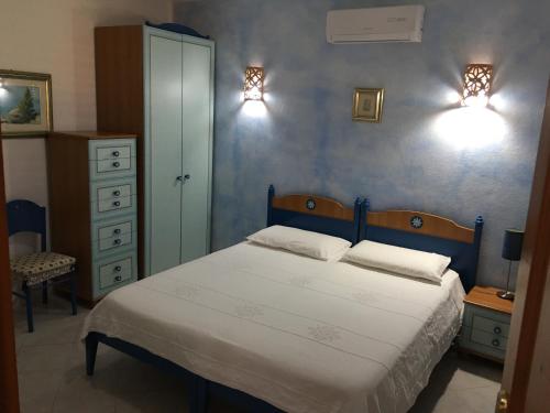 ラ・マッダレーナにあるB&B Mongiardinoのベッドルーム1室(ベッド1台、壁に照明2つ付)