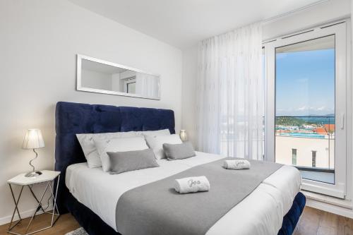 a bedroom with a large bed with a large window at Luxury Apartment Joo & Joo in Murter