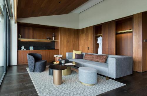 Una sala de estar con un sofá, una mesa y sillas. en MUH SHOOU XIXI HOTEL HANGZHOU, en Yuhang