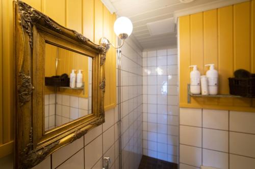 a bathroom with a mirror and a sink and a shower at Boutique Hotel Langin Kauppahuone in Raahe