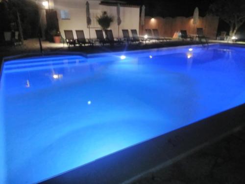 uma grande piscina iluminada à noite em Marketos Apartments em Svoronata