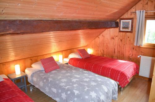 モルジヌにあるMAISON ROSE 3のベッド2台 木製の壁の部屋