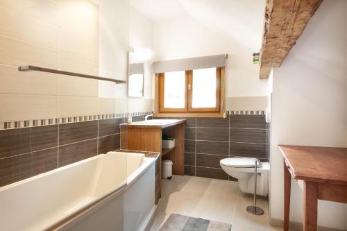een badkamer met een bad, een toilet en een wastafel bij MAISON ROSE 3 in Morzine