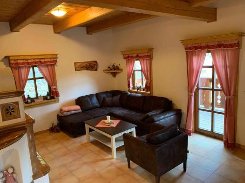 a living room with a leather couch and a table at Chalupa na Leskové in Velké Karlovice