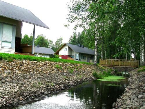 a river in front of a house with houses at Holiday Linnunlahti in Joensuu