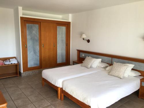 a bedroom with two beds and a wooden cabinet at CDM, Puerto del Carmen, entre Playa Chica y Playa Grande in Puerto del Carmen