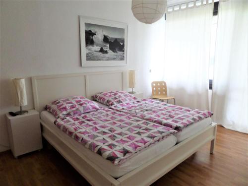een slaapkamer met een bed met een roze dekbed bij Beim Wels in Bad Zwischenahn