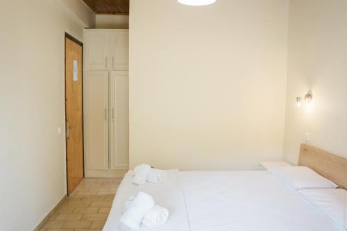 a bedroom with two beds with towels on them at Afroditi Pansion in Agios Nikitas