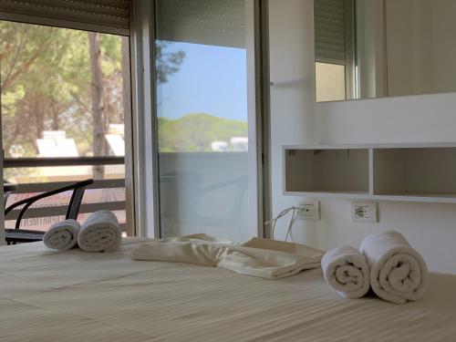 a bedroom with a bed with towels on it at EME APARTMENTS - Kompleksi Lura 2 Gjiri i Lalzit in Draç