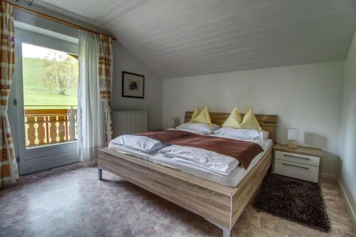 a bedroom with a bed and a large window at Garni Sonnegg in Petersberg