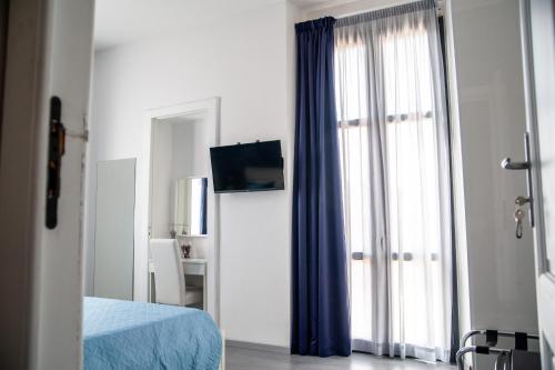a bedroom with a bed and a window with a television at Casa del Marchese B&B in Riposto