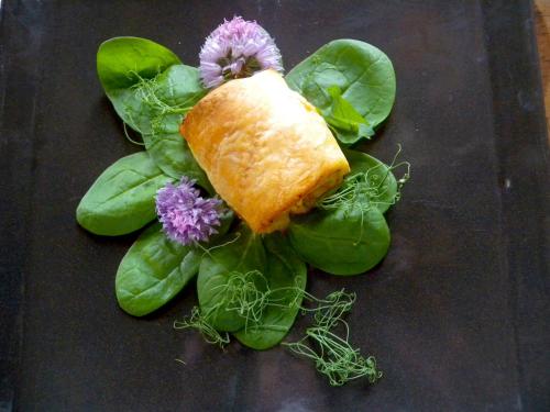 un pezzo di cibo che si trova sopra le verdure verdi di LE MOULIN DE BOULÈDE a Monflanquin