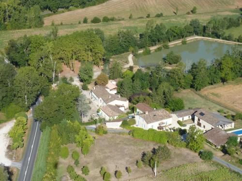 une vue aérienne d'une maison avec un lac dans l'établissement LE MOULIN DE BOULÈDE, à Monflanquin