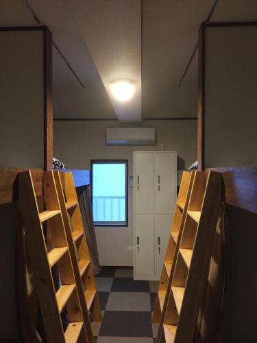 a room with shelves and a window and a door at Heart Hostel and Diner 女性専用Onlyfemale in Ise