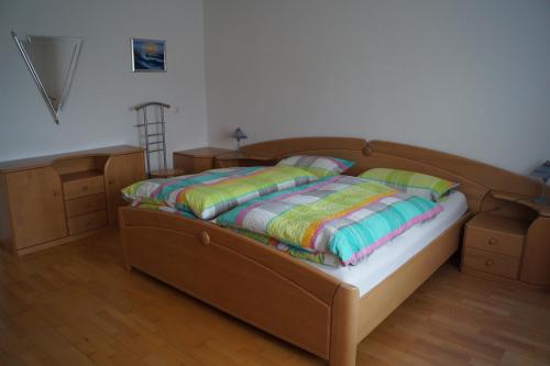 1 dormitorio con cama de madera y cabecero de madera en Ferienwohnung Hofbauer, en Hofkirchen