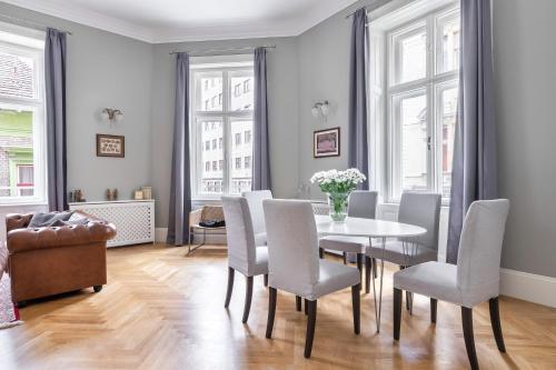 una sala da pranzo con tavolo e sedie di Spacious Victorian Residence by Grand Boulevard a Budapest