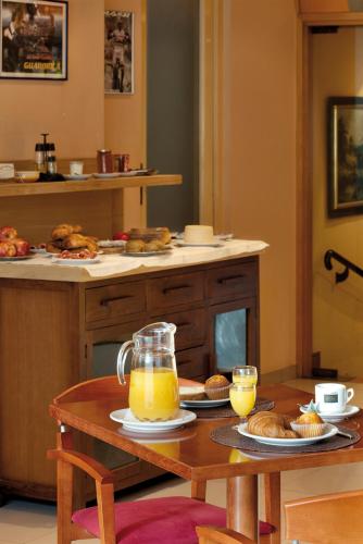 Una cocina con una mesa con una jarra de jugo de naranja. en Apartament Piteus Centre, en Sant Llorenç de Morunys