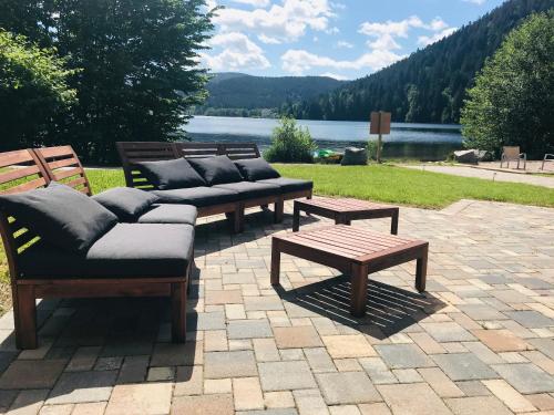 a group of benches with pillows and a table at Le Chalet au bord du lac in Gérardmer