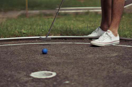 une personne fait une partie de minigolf dans l'établissement Le Chalet au bord du lac, à Gérardmer