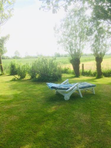a picnic table in a grassy field with a bench at Ferienwohnanlage Sturmhöhe in Welt