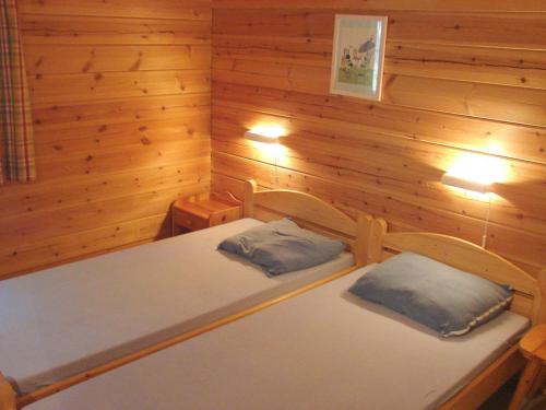 MaurouxにあるChalet Cahors - 4 pers.の木造キャビン内のベッド2台が備わる部屋