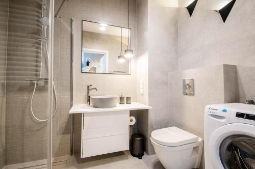 a bathroom with a sink and a washing machine at Beautiful apartment in the city center in Gdańsk