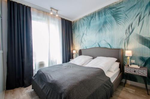 a bedroom with a bed with a blue wall at Beautiful apartment in the city center in Gdańsk