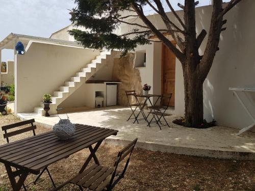 een patio met een tafel, een boom en een trap bij La Villetta Suite in Favignana