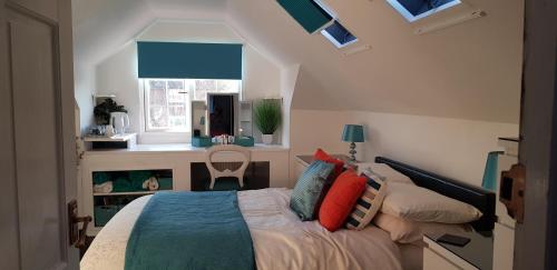 a bedroom with a bed with pillows and a window at Harbour Lights, 30 Manor Lane in Selsey