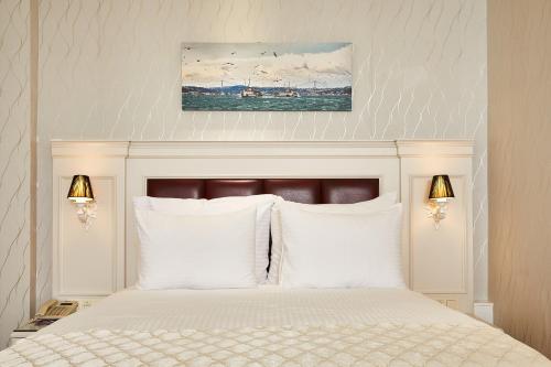 ein Schlafzimmer mit einem weißen Bett mit weißen Kissen in der Unterkunft Albinas Hotel Old City in Istanbul
