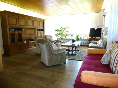- un salon avec un canapé, des chaises et une table dans l'établissement Apartment near the forest in Hullersen, à Einbeck
