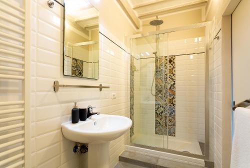 a white bathroom with a sink and a shower at Casa Dreosti in Cortona