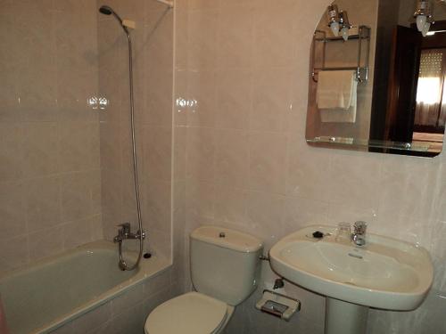 a bathroom with a toilet and a sink and a tub at APARTAMENTOS RURALES PERNÚS in Colunga