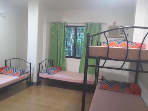 a room with three bunk beds and a window at OMG Guesthouse Room for 6 in Licup