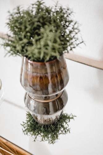 a vase filled with greenery sitting on a table at Das Gästehaus in Sankt Veit am Vogau