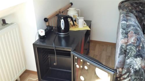 uma máquina de café numa mesa ao lado de um sofá em Zwei ruhige, private Gästezimmer nahe U-Bahn em Nurembergue