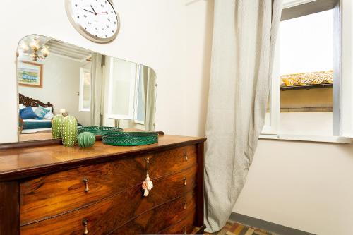 a dresser with a mirror and a clock on the wall at Casa Dreosti in Cortona