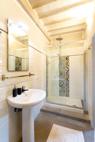 a white bathroom with a sink and a shower at Casa Dreosti in Cortona